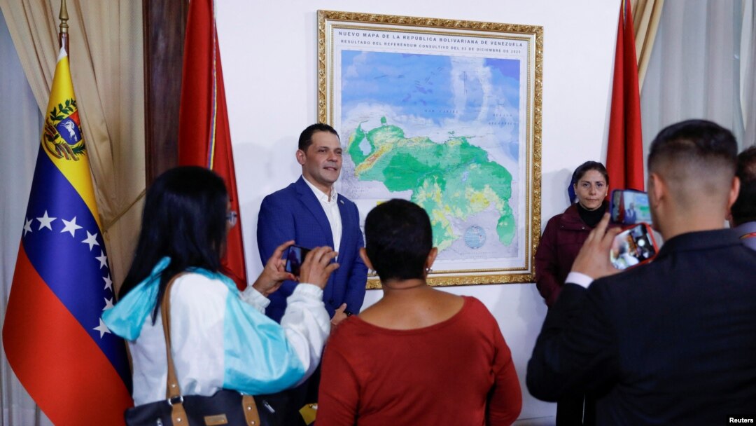People take photos during an event to unveil a map of Venezuela showing Guyana's Essequibo region as part of the country, in Caracas, Venezuela, on Dec. 8, 2023.