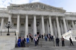 Members of the House of Representatives walk down the steps of Capitol Hill in Washington, March 27, 2020, after passing a coronavirus rescue package.