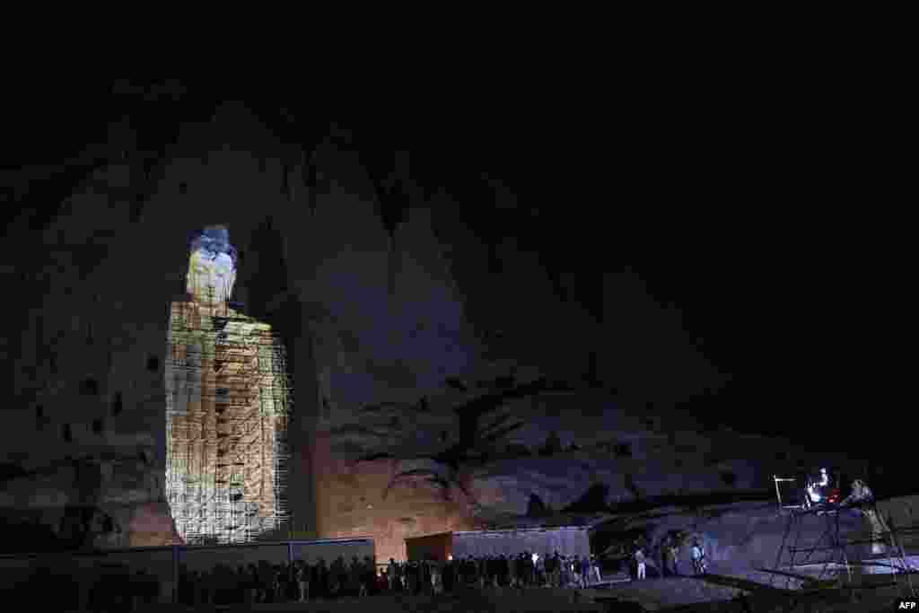 People watch a three-dimensional projection of the 56-meter-high Salsal Buddha at the site where the Buddhas of Bamiyan statues stood prior to being destroyed by the Taliban in March 2001, in Bamiyan province, Afghanistan.