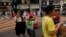 Tourists from mainland China eat street food on downtown street in Hong Kong, May 11, 2011.