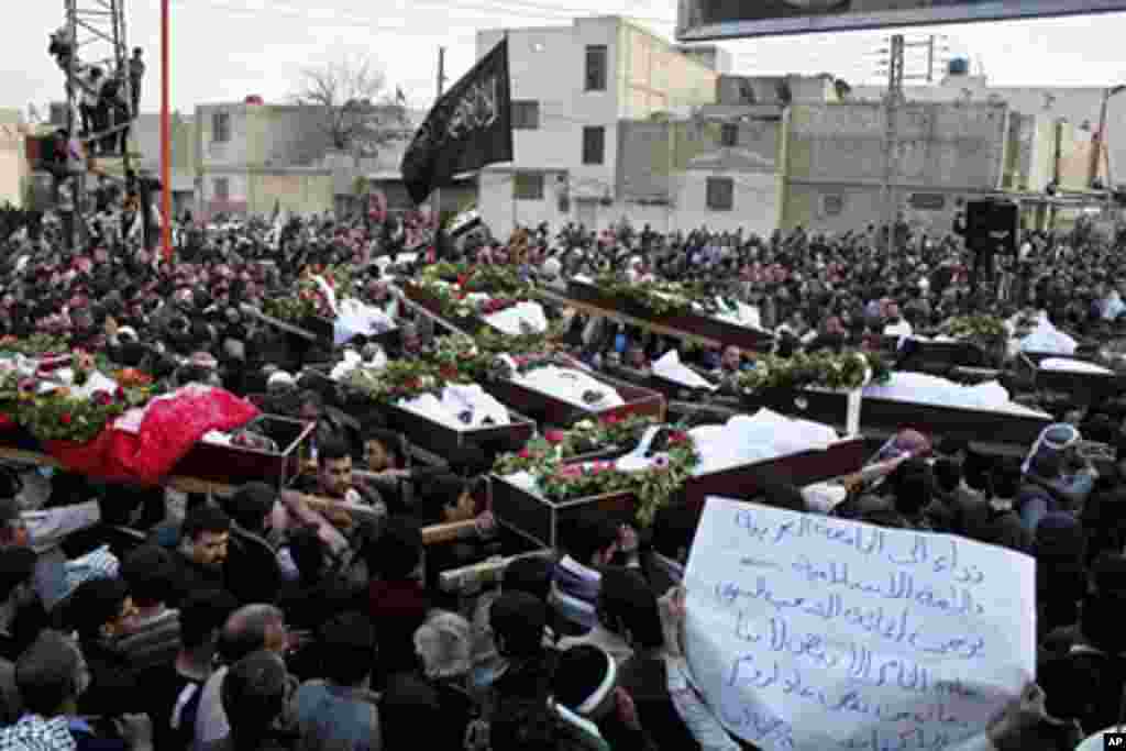 Syrians attend a mass funeral for people anti-government protesters said were killed by Syrian security forces in earlier protests against Syria's President Bashar al-Assad, in Duma near Damascus, March 26, 2012. (Reuters)