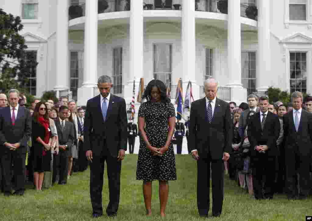 President Barack Obama, first lady Michelle Obama, Vice President Joe Biden, and others, stand on the South Lawn of the White House in Washington, as they observe a moment of silence to mark the 13th anniversary of the 9/11 attacks.