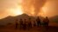 FILE - Firefighters monitor the advancing Line Fire in Angelus Oaks, Calif., Sept. 9, 2024. 