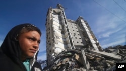 A Palestinian walks by a residential building destroyed in an Israeli strike in Rafah, Gaza Strip, on March 9, 2024.