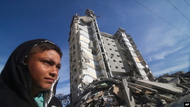 Palestinezët pranë një blloku banimi që u shkatërrua nga sulmet izraelite në Rafah, Rripi i Gazës, 9 mars, 2024.