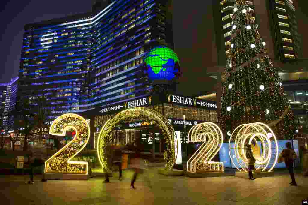 People walk in front of the upcoming new year decorated for Christmas and New Year celebrations in Novy Arbat street in Moscow, Russia.