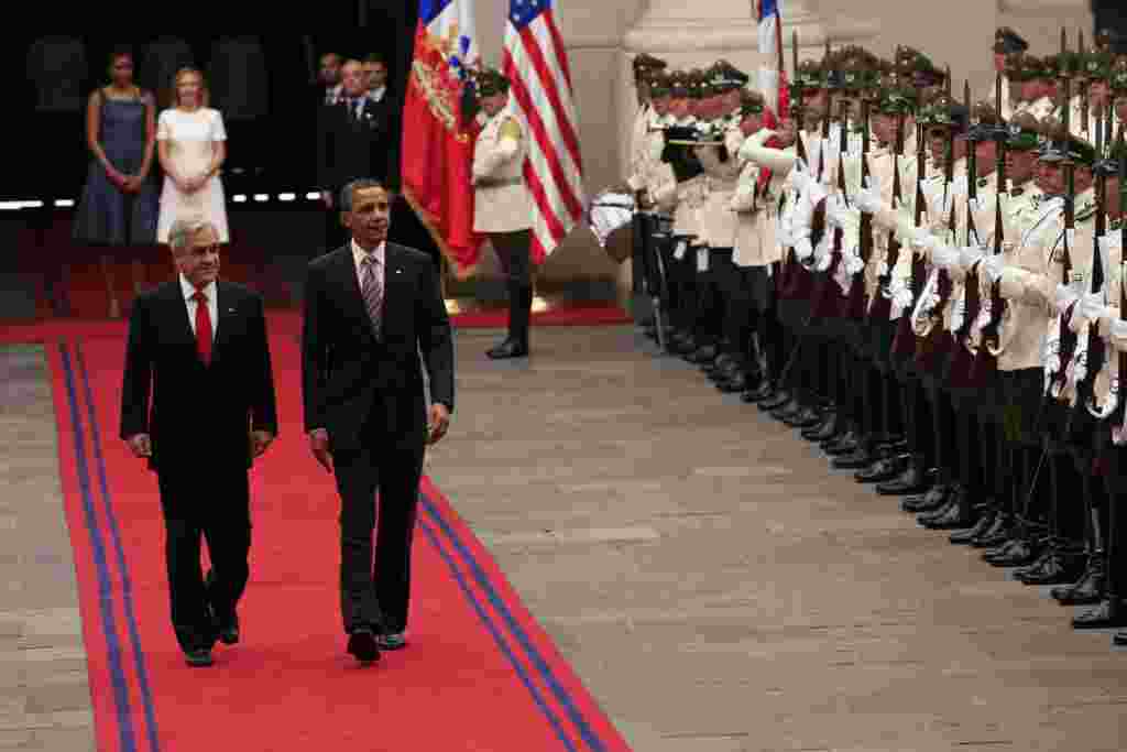 Los mandatarios Barack Obama y Sebastian Piñera desfilan al frente de la corte de honor.