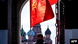 資料照：在莫斯科紅場，一名俄羅斯共產黨的支持者舉著一面蘇共的旗幟。 （2020年5月1日）