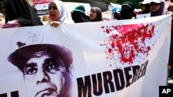 FILE - Supporters of ousted Egyptian President Mohammed Morsi carry a banner against Abdel Fattah el-Sissi during a demonstration in front of the National Council for Human Right building in Cairo.