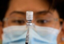 Seorang petugas kesehatan menyiapkan dosis vaksin Pfizer COVID-19 di klinik vaksinasi keliling Los Angeles County di Los Angeles, 14 Mei 2021. (AFP)