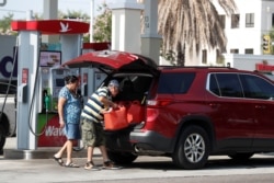 A man loads 5-gallon gas tanks in his car at a Wawa gas station, in Tampa, Fla., May 12, 2021.