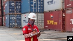 Seorang pekerja berada di dekat tumpukan kontainer di terminal Indonesia Port Corporation di Pelabuhan Tanjung Priok, Jakarta, 8 Oktober 2021. (Foto: AP/Tatan Syuflana)