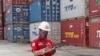 FILE - A worker makes a note near stacks of containers at an Indonesia Port Corporations terminal at Tanjung Priok Port in Jakarta, Indonesia, Oct. 8, 2021.
