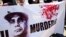 FILE - Supporters of ousted Egyptian President Mohammed Morsi carry a banner against Abdel Fattah el-Sissi during a demonstration in front of the National Council for Human Right building in Cairo. 