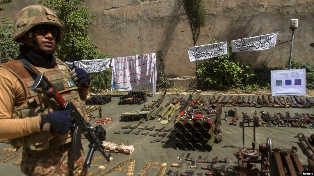 Tentara Pakistan menjaga berbagai macam senjata militan Taliban yang disita dalam operasi di Miranshah, Waziristan utara (Juli 2014).