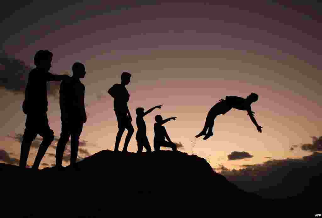 Palestinian youths practice parkour at sunset in Gaza City.