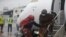 FILE - Passengers wearing face masks to protect against coronavirus disembark from a plane arriving from Abuja at the Murtala Mohammed Airport in Lagos, Nigeria, on July 9, 2020. 