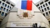 Workers put up a new sign reading "State Council of the Crimean Republic" at the parliament building in Simferopol, March 19, 2014.