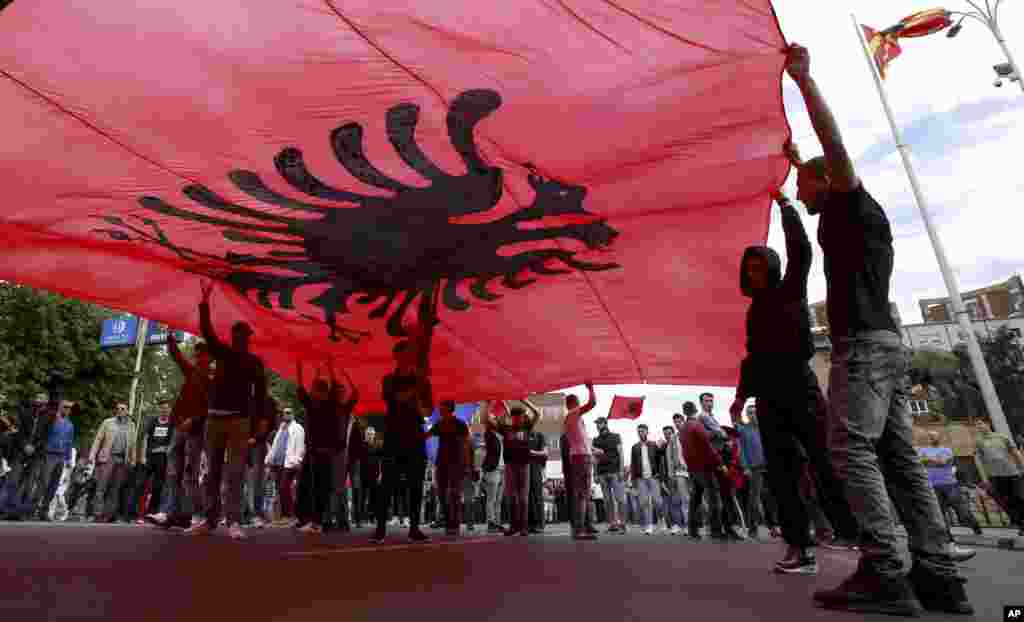 Ethnic Albanians hold a large Albanian flag, during a protest by ethnic Albanian civic organizations and several minor political parties demanding the establishment of the rule of law, in front of the parliament building in Skopje, Macedonia.