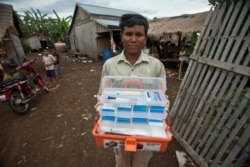 FILE - Village malaria worker Phoun Sokha, 47, shows his malaria medicine kit at O'treng village on the outskirts of Pailin, Cambodia, Aug. 29, 2009.