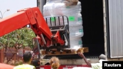 Workers from Doctors Without Borders unload emergency medical supplies to deal with an Ebola outbreak in Conakry, Guinea, March 23, 2014. 