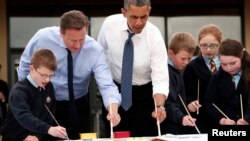 El primer ministro David Cameron (segundo de la izquierda) y el presidente Barack Obama pintan junto a estudiantes de la escuela primaria Enniskillen en Irlanda del Norte.