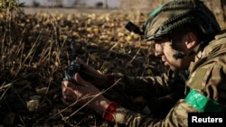 A member of Ukraine's 24th mechanized brigade installs a landmine on the outskirts of the town of Chasiv Yar in Donetsk region, Ukraine October 30, 2024. Ukrainian Armed Forces/Handout via REUTERS 