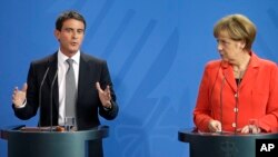 PM Perancis Manuel Valls (kiri) dan Kanselir Jerman Angela Merkel memberikan konferensi pers bersama di Berlin hari Senin (22/9).