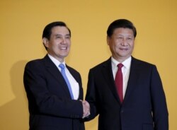 FILE - Chinese President Xi Jinping shakes hands with Taiwan's President Ma Ying-jeou during a summit in Singapore November 7, 2015.