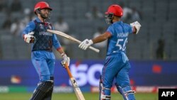 Afghanistan's Azmatullah Omarzai (L) celebrates with his captain Hashmatullah Shahidi after scoring a half-century (50 runs) during the 2023 ICC Men's Cricket World Cup one-day international (ODI) match between Afghanistan and Sri Lanka at the Maharashtra