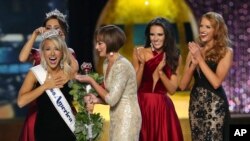 The outgoing Miss America, Betty Cantrell, back left, crowns the Miss America winner Miss Arkansas Savvy Shields, while Lynn Weidner, third right, assists, as Miss Maryland Hannah Brewer, second right, and Miss Texas 2016 Caroline Carothers, look on durin