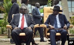 FILE - South Sudan's then-First Vice President Riek Machar, left, looks across at President Salva Kiir, right, as the two sit to be photographed, April 29, 2016.