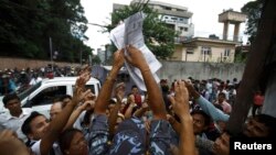 Nepalese people reach out for voter registration forms before the deadline to register for the upcoming Constituent Assembly Election, to be held in November 19, at the Kathmandu District Election Office in Kathmandu July 15, 2013. REUTERS/Navesh Chitraka