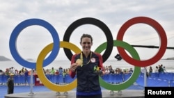 La triathlète Gwen Jorgensen des États-Unis pose avec sa médaille d'or aux Jeux olympiques d'été de 2016 à Rio de Janeiro, le 20 août 2016. REUTERS/Jeff Pachoud/Pool 