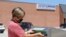 A woman drops her application for a mail-in ballot at the Douglas County Election Commission office in Omaha, Nebraska, Aug. 19, 2020. 
