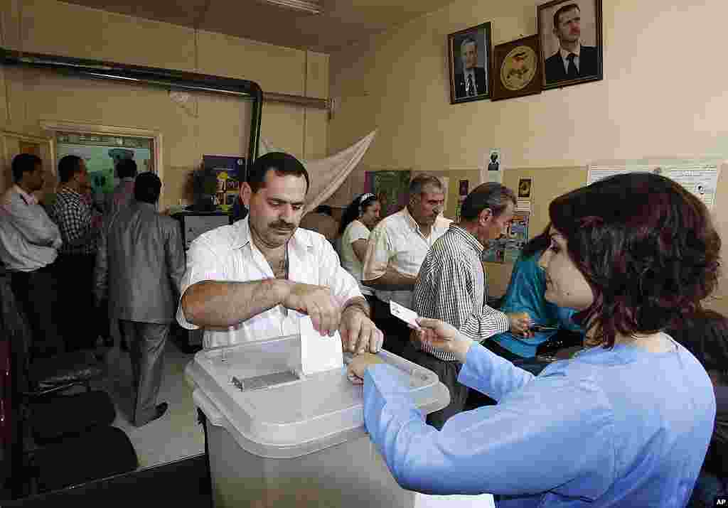 In this photo taken during a government-organized tour, a Syrian man casts his vote during the parliamentary elections. (AP)