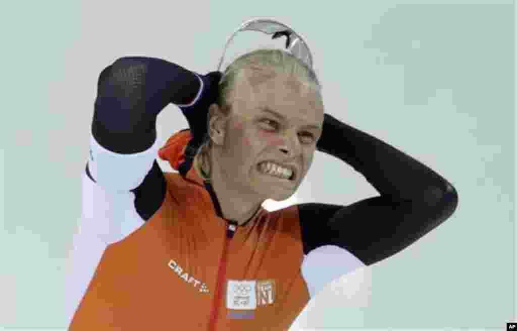 Silver medalist Koen Verweij of the Netherlands grabs his hair when the race was declared a tie with gold medalist Poland's Zbigniew Brodka  in the men's 1,500-meter speedskating race at the Adler Arena Skating Center during the 2014 Winter Olympics in So