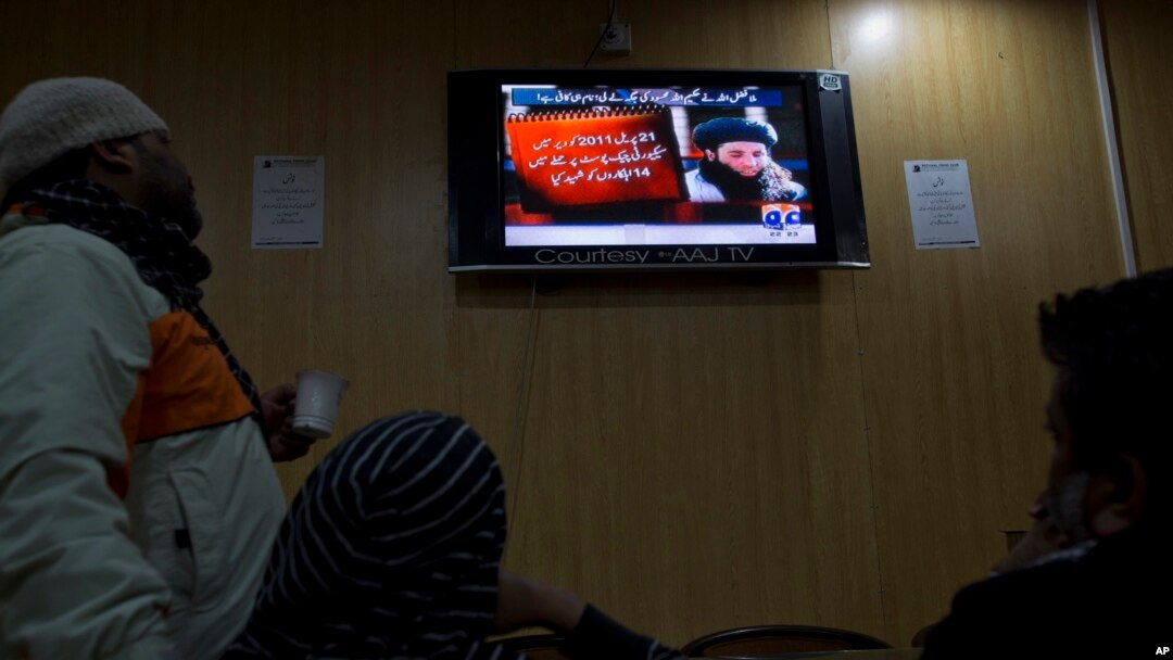 FILE - People watch a TV news report about the leader of the Pakistani Taliban, Mullah Fazlullah, at a coffee shop in Islamabad, Pakistan, Nov. 7, 2013.