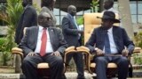 FILE - In thisApril 29, 2016 file photo, South Sudan's then-First Vice President Riek Machar, left, looks across at President Salva Kiir, right, as the two sit to be photographed following the first meeting of a new transitional coalition government, in the capital Juba, South Sudan. 