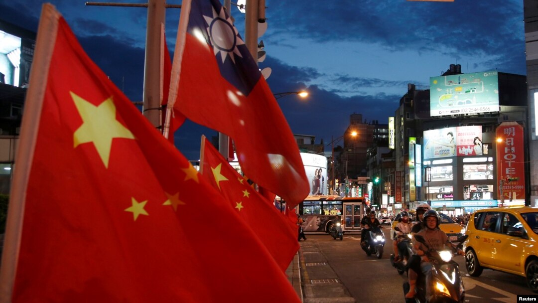 FILE - Flags of China and Taiwan flutter next to each other during a rally calling for peaceful reunification, in Taipei, May 14, 2016.