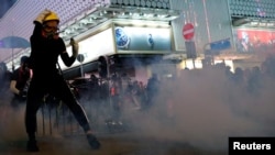香港抗議者在警察施放的催淚彈煙霧中與港警對峙。 （2019年10月20日）