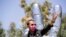 Musician Ringo Starr wears a face mask as he poses in front of his sculpture to celebrate his 80th birthday during the outbreak of the coronavirus disease (COVID-19), in Beverly Hills, California, July 7, 2020. 