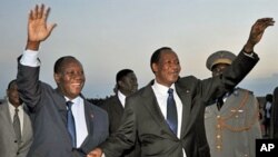 Ivory Coast President Alassane Ouattara (L) greets president Blaise Compaore of Burkina Faso at Yamoussoukro airport, a day ahead of his inauguration, May 20, 2011