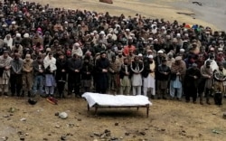 FILE - Pakistani Kashmiris attend a funeral prayer for a man, reportedly killed by shelling from Indian troops, at the Line of Control in Pakistani Kashmir, Nov. 14, 2020.