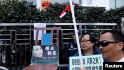 资料照 香港抗议者在圣诞节在中联办前摆放一张空椅子和刘晓波遗孀刘霞的照片,呼吁中国当局解除对刘霞的软禁。(2017年12月25日)