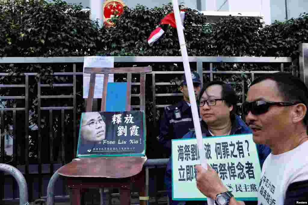 在圣诞节，香港抗议者在中联办大楼前摆放一张空椅子和刘晓波遗孀刘霞的照片，呼吁中国当局解除对刘霞的软禁。他们把圣诞帽扔进围栏。（2017年12月25日）