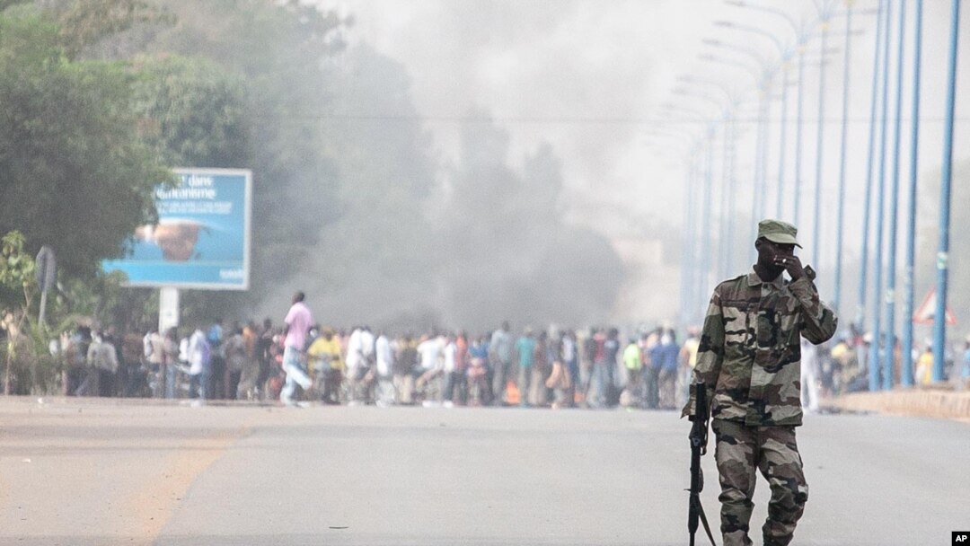 A soldier patrols near a burning road block outside the paratrooper camp, home of the former president's Red Beret presidential guard, in Bamako, February 8, 2013.
