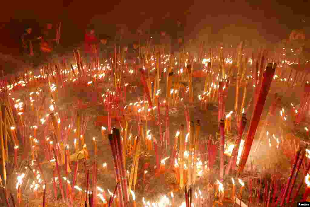 People burn incense as they pray for good fortune on the first day of the Chinese Lunar New Year, at a temple in Chengdu, Sichuan province.