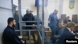 Son of Ukrainian Interior Minister Arsen Avakov, Oleksandr Avakov, left, who is under investigation over suspected corruption, is seen inside a defendant's cage during a court hearing in Kyiv, Ukraine, Nov. 1. Ukrainian investigators fear corruption probes could soon be buried by a release of thousands of old cases.