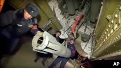 In this photo made from the footage taken from Russian Defense Ministry official web site, Russian air force personnel load bombs onto a Tu-22 bomber in preparation for a bombing mission against targets in Syria, Nov. 17, 2015.